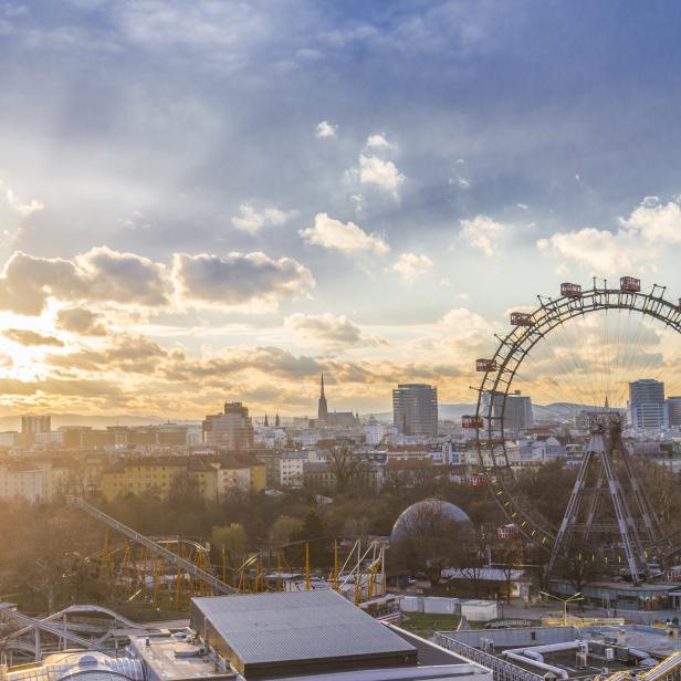 Das Wiener Riesenrad und die Skyline der Stadt bei Sonnenuntergang.