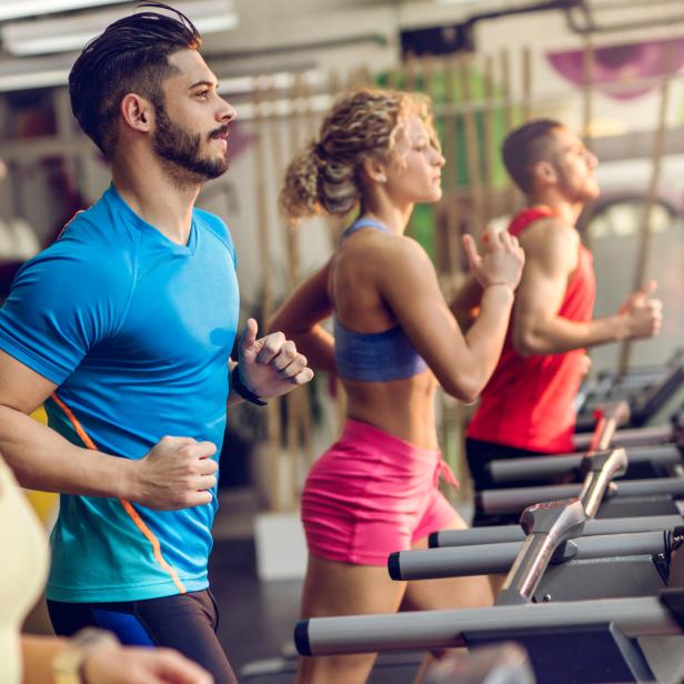 Mehrere Personen trainieren auf Laufbändern in einem Fitnessstudio.