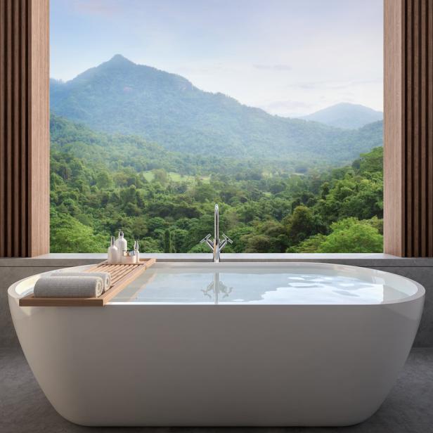 Eine Badewanne mit Blick auf eine grüne Hügellandschaft.