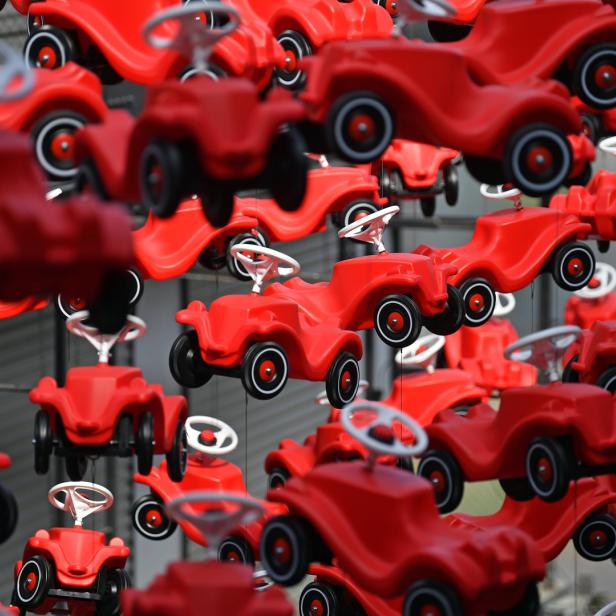 Viele rote Bobby-Cars hängen in der Luft.