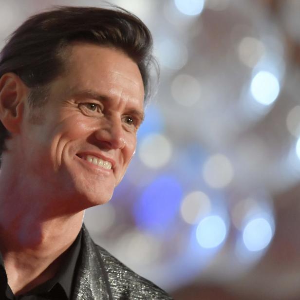 Jim Carrey lächelt in einem glitzernden Sakko.