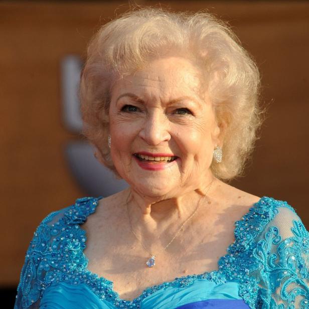 Betty White lächelt in einem blauem Kleid.
