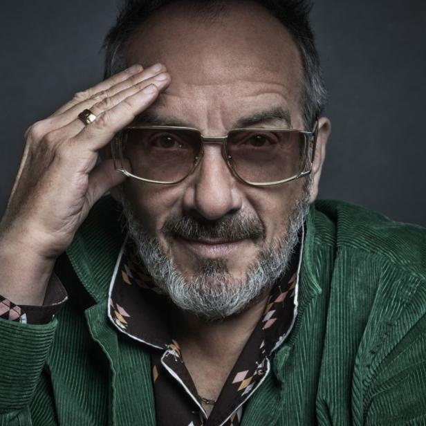 Porträt von Elvis Costello mit Brille und Cordjacke.