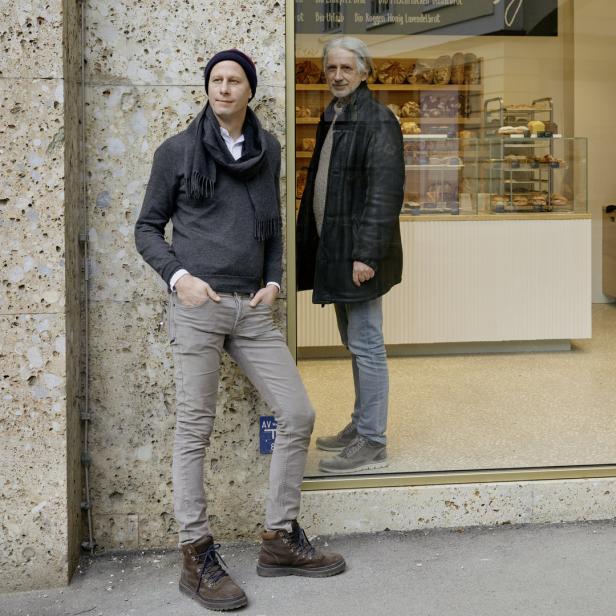 Zwei Männer stehen vor dem Schaufenster einer Bäckerei.