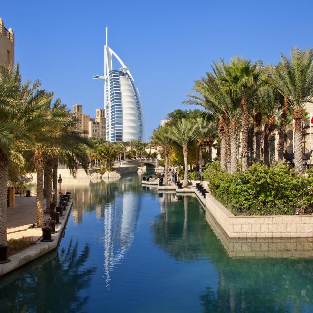 Das Burj al-Arab Hotel in Dubai, umgeben von Palmen und Wasserwegen.