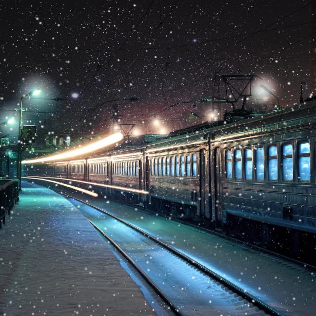 Ein Zug fährt nachts durch eine verschneite Bahnhof.