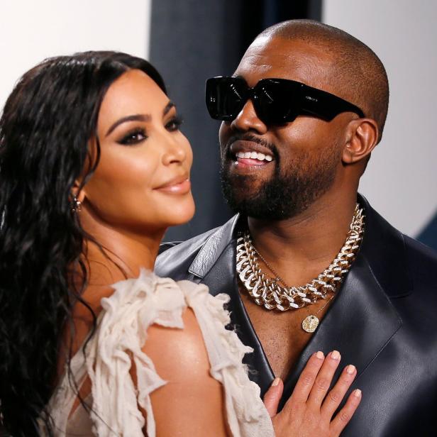 Kim Kardashian und Kanye West posieren zusammen auf einem Event.