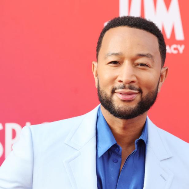 Ein Porträt von John Legend vor einem roten Hintergrund.
