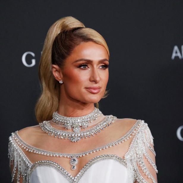 Paris Hilton trägt ein weißes Kleid mit auffälligem Schmuck.