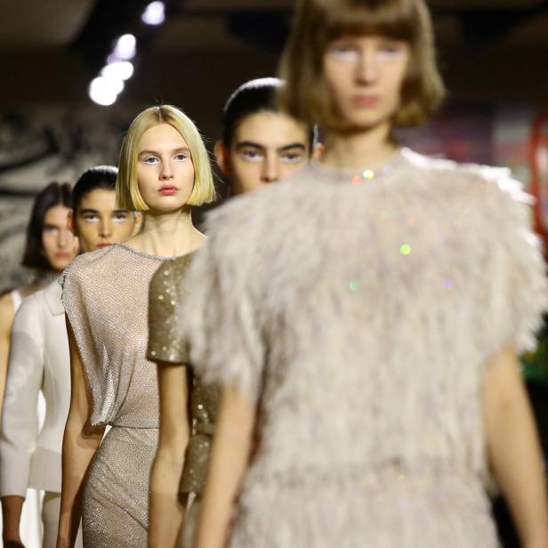 Models präsentieren während einer Modenschau Kleidung mit Pailletten und Federn.