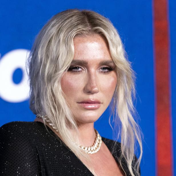 Porträt der Sängerin Kesha mit blonden Haaren und einer Perlenkette.
