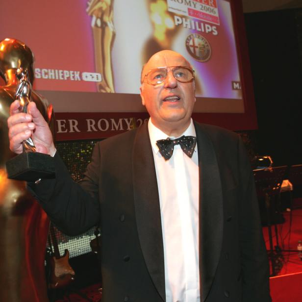 Ein Mann im Smoking hält eine Romy-Statue in der Hand.