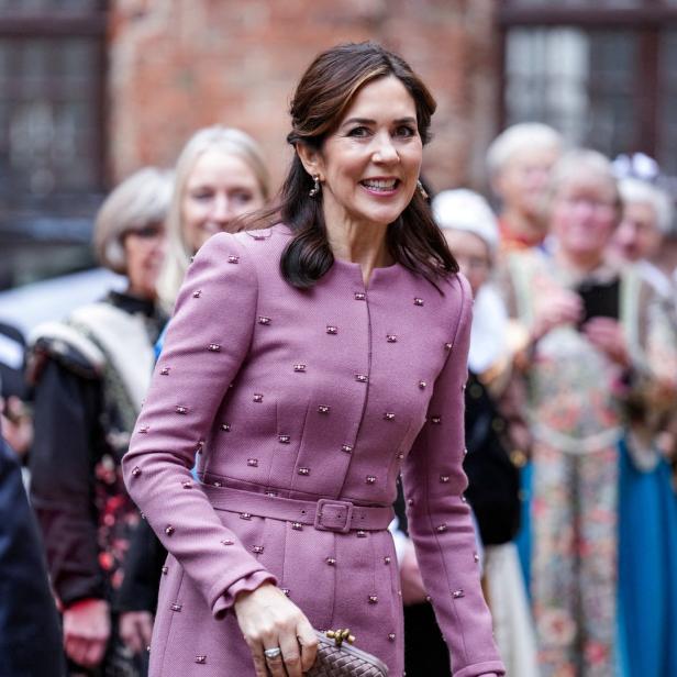 Kronprinzessin Mary von Dänemark lächelt in einem rosa Mantel.