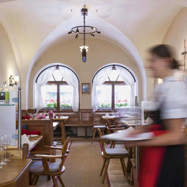 Ein Innenraum des Restaurants Döllerer mit einer Kellnerin im Vordergrund.