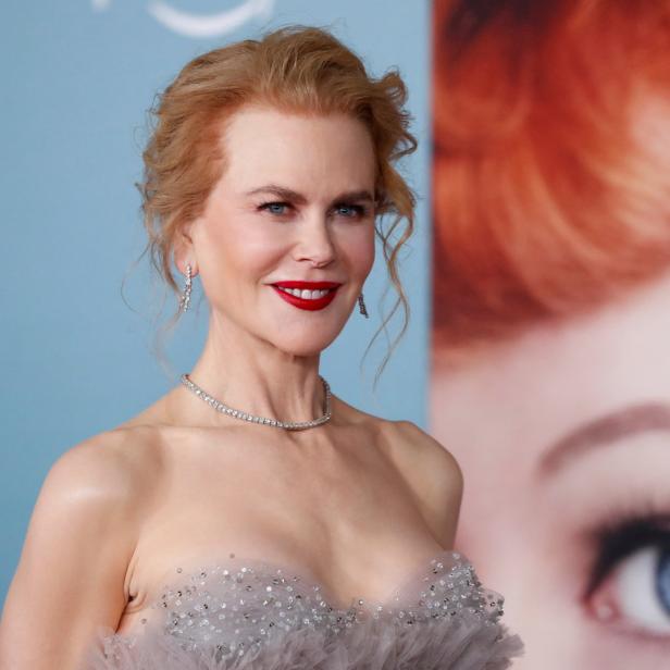 Nicole Kidman auf einem roten Teppich vor einem Poster mit dem Auge einer Frau.
