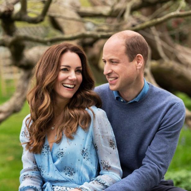 Prinz William und Prinzessin Kate sitzen lächelnd im Freien.