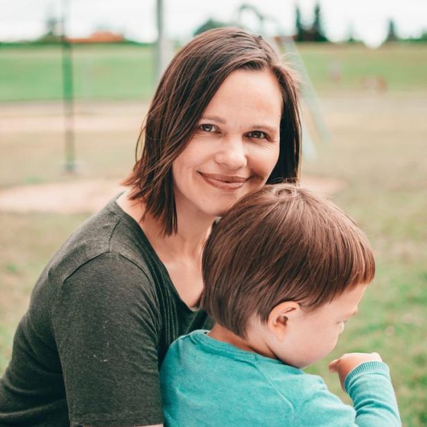 Eine Frau umarmt ein Kind im Freien.