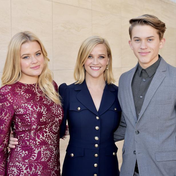 Reese Witherspoon posiert mit ihren Kindern Ava und Deacon vor einer Wand.
