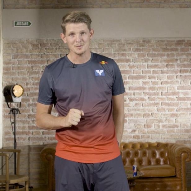 Thomas Morgenstern in Sportkleidung vor einer Backsteinwand in der Freizeit Academy.