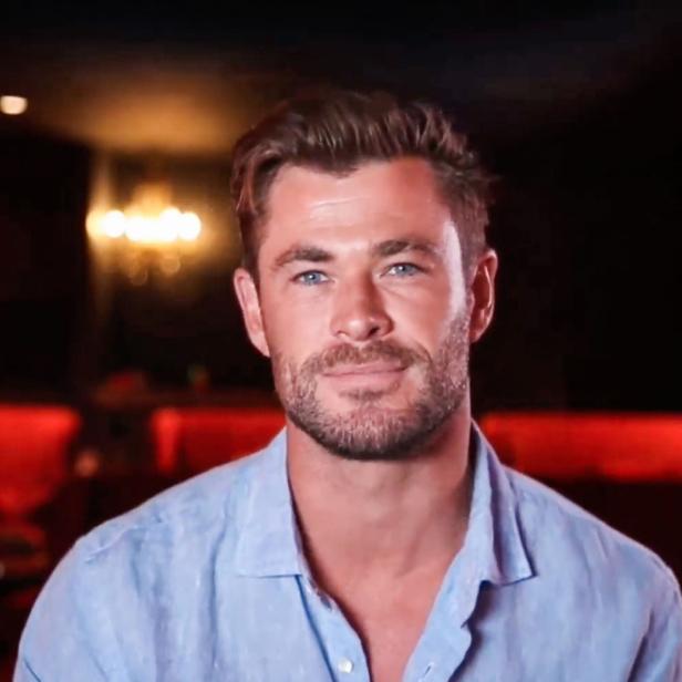 Ein Porträt von Chris Hemsworth vor einem dunklen Hintergrund.