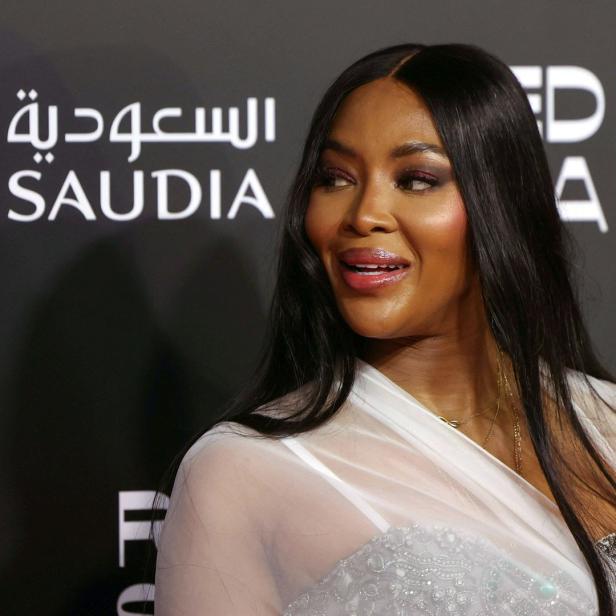 Naomi Campbell posiert vor einem Hintergrund mit dem Saudia-Logo.