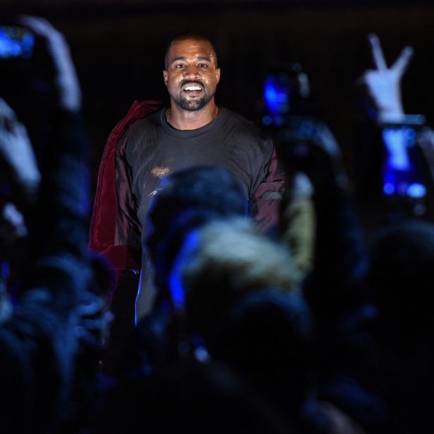 Kanye West steht vor einer jubelnden Menge, die Handys in die Höhe hält.