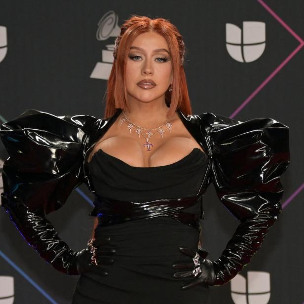 Christina Aguilera posiert in einem schwarzen Kleid mit Puffärmeln auf dem roten Teppich.