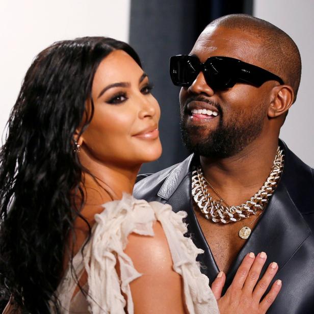 Kim Kardashian und Kanye West posieren zusammen auf einem Event.