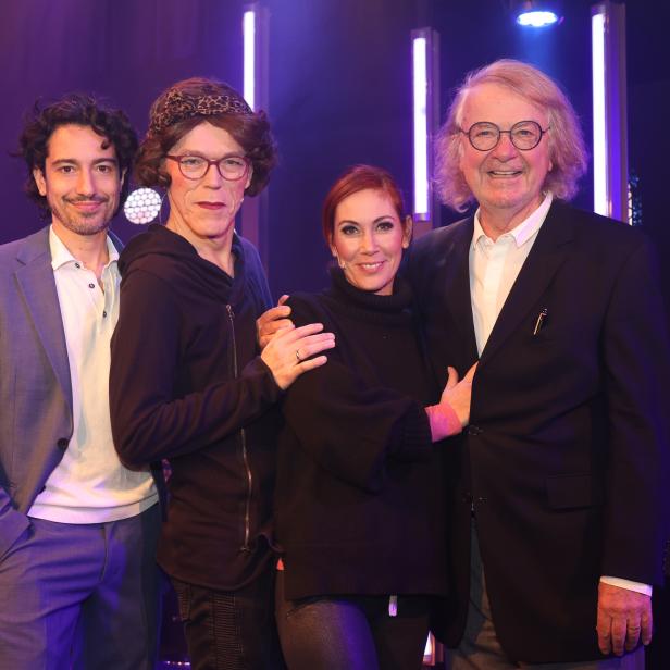 Vier Personen posieren auf einer Bühne für ein Premierenfoto.