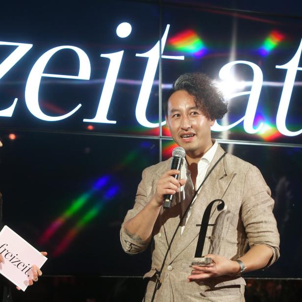 Ein Mann hält eine Auszeichnung der „Freizeit“ in der Hand und spricht ins Mikrofon.
