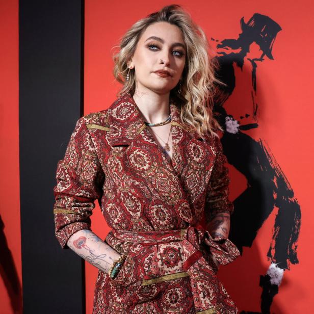 Paris Jackson posiert vor einem roten Hintergrund mit einer Silhouette von Michael Jackson.