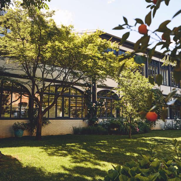 Die Manufaktur von Louis Vuitton, umgeben von einem grünen Garten.