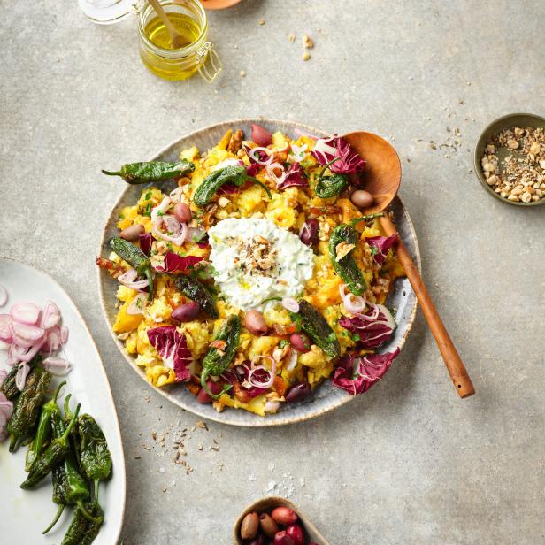 Ein Kartoffelsalat mit Pimientos de Padrón, Radicchio, Oliven und Joghurt-Dip wird serviert.
