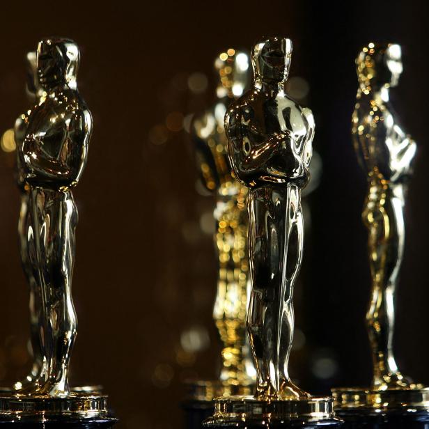 Mehrere goldene Oscar-Statuetten stehen auf einem Tisch.