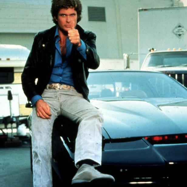 David Hasselhoff posiert auf dem Auto K.I.T.T. aus der Serie „Knight Rider“.