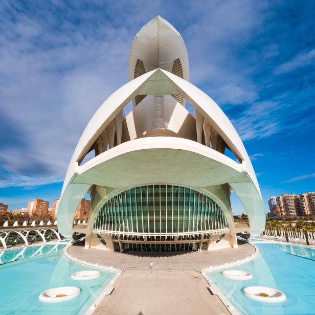 Das L'Oceanogràfic in Valencia, ein futuristisches Gebäude mit Wasserbecken im Vordergrund.