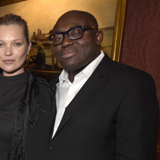 Kate Moss und Edward Enninful posieren vor einem Gemälde.