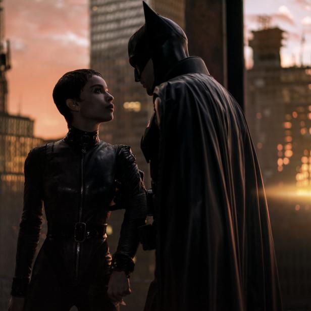 Batman und Catwoman stehen vor der Skyline von Gotham City.