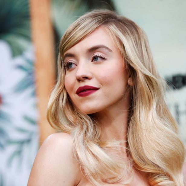 Sydney Sweeney blickt mit blonden, gewellten Haaren über ihre Schulter.
