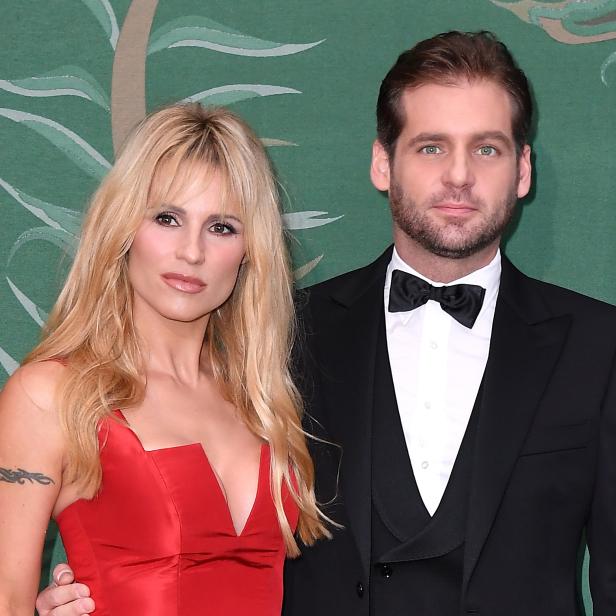 Michelle Hunziker und Alessandro Carollo posieren zusammen vor einem grünen Hintergrund.