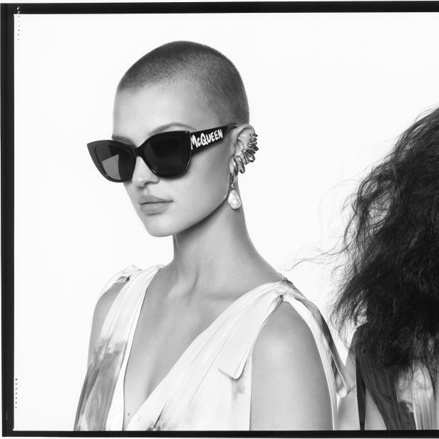 Schwarz-Weiß-Foto zweier Frauen, eine mit „McQueen“-Sonnenbrille und Ohrschmuck.