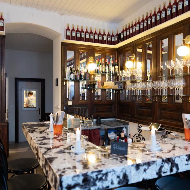 Innenansicht einer Bar mit Campari-Flaschen und einer Marmorbar.