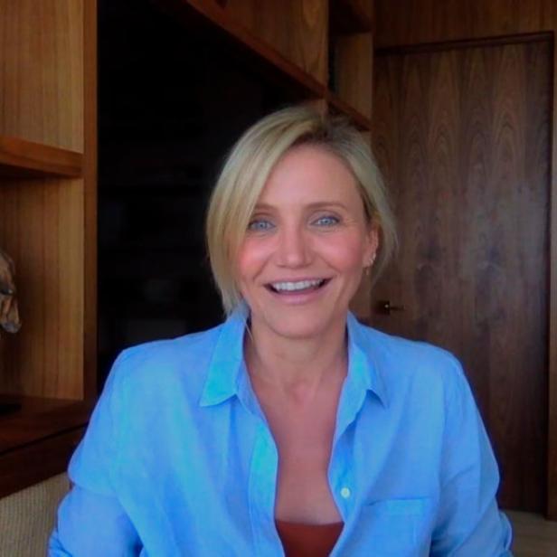 Cameron Diaz lächelt vor einem hölzernen Bücherregal.