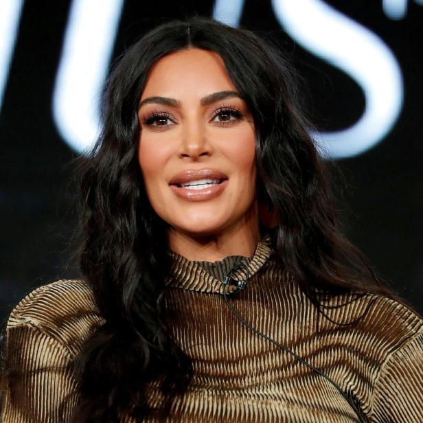 Kim Kardashian posiert vor einem schwarzen Hintergrund.