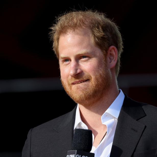 Prinz Harry bei einer Veranstaltung mit einem Mikrofon vor dem Mund.