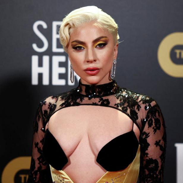Lady Gaga auf dem roten Teppich mit blonden Haaren und einem schwarzen Kleid.