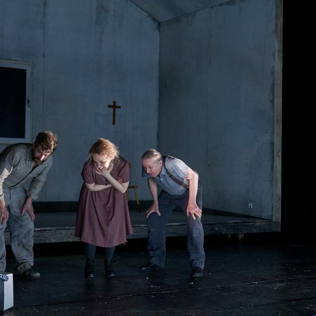 Szene aus einem Theaterstück mit vier Schauspielern auf einer Bühne.