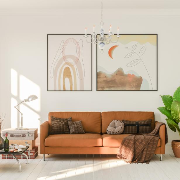 Ein Wohnzimmer mit einem orangefarbenen Sofa, Pflanzen und abstrakten Bildern.