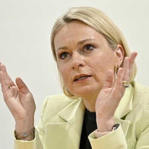 Eine Frau in einem hellgrünen Blazer gestikuliert mit ihren Händen.