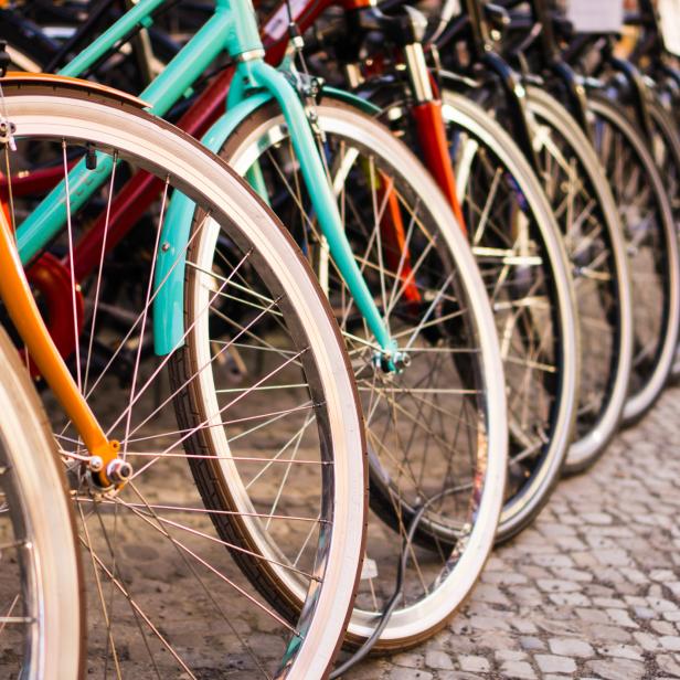 Mehrere Fahrräder unterschiedlicher Farben stehen aneinandergereiht.